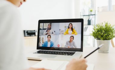 Asia businesswoman using laptop talk to colleagues about plan in video call meeting while working from home at living room. Self-isolation, social distancing, quarantine for corona virus prevention.